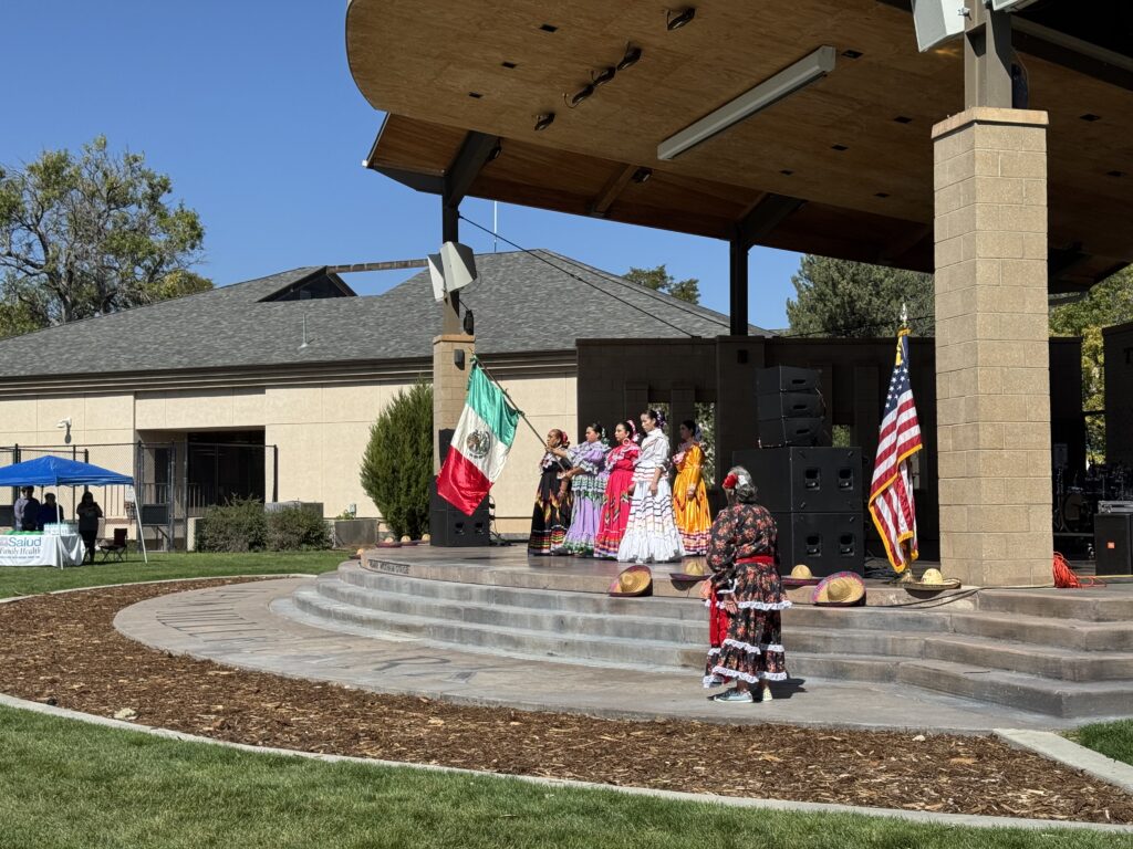 Folkloric dancers in traditional dress performing at the Glenn Miller Park bandshell in Fort Morgan